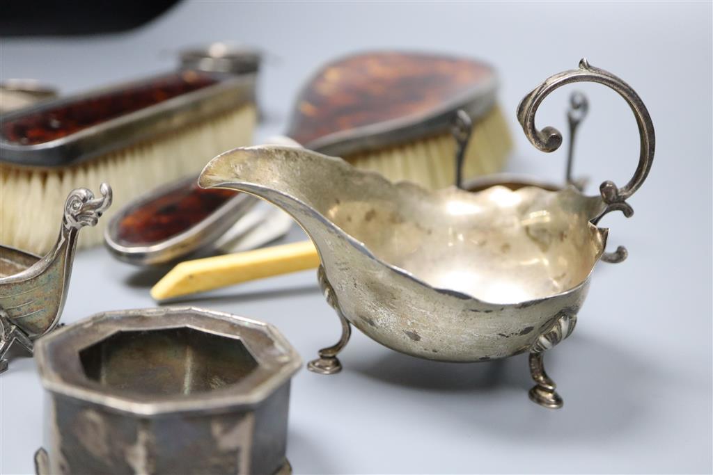 A silver mustard pot, silver sauceboat, three silver and one sterling napkin ring, two silver tea strainers etc.